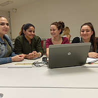 Vier Schülerinnen vor ihrem gemeinsamen Laptop im Klassenzimmer