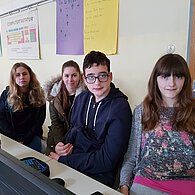Schüler und Schülerinnen vor ihrem gemeinsamen Computer.