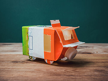 Ein Spielzeugauto gebastelt aus einer Milchverpackung